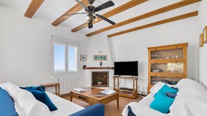 Un salon comprenant deux canapés, une table basse, une cheminée, un téléviseur et un meuble en bois.