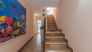 A staircase leading to a landing with a mural of marine life on the wall.