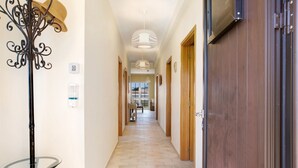 A hallway with a glass table, a coat rack, and a door. - Villa 'Retiro Praia' with Mountain View, Private Terrace and Wi-Fi (Campo de Baixo)