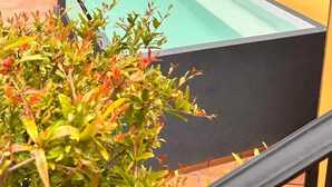 A swimming pool with a glass enclosure, surrounded by greenery and a hillside. - Casa Los Jazmines with Pool & Jacuzzi – Sea Views, Wi-Fi, Air Conditioning (Agaete)