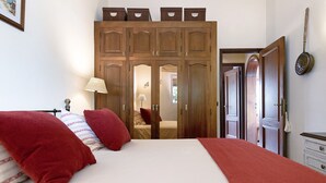 A bedroom with a large bed, wooden wardrobe, and a lamp. - Casa Los Jazmines with Pool & Jacuzzi – Sea Views, Wi-Fi, Air Conditioning (Agaete)