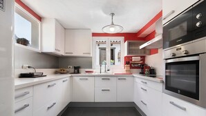 A modern kitchen with white cabinets, a Bosch oven, and a window with a view of the outside. - Holiday Home "Los Veroles" with Sea View, Private Heated Pool and Wi-Fi (Agaete)