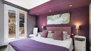 A bedroom with a large bed, a nightstand, a lamp, a painting, and a sliding glass door leading to a balcony. - Holiday Home "Los Veroles" with Sea View, Private Heated Pool and Wi-Fi (Agaete)