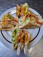 Un plato con cuatro sándwiches a la parrilla cortados en triángulos.