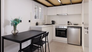 Een moderne keuken met witte kastjes, een zwart aanrecht en een roestvrijstalen vaatwasser.