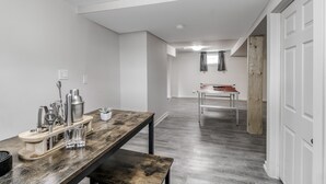 Una cocina moderna con una mesa de madera, utensilios de bar y una banca.
