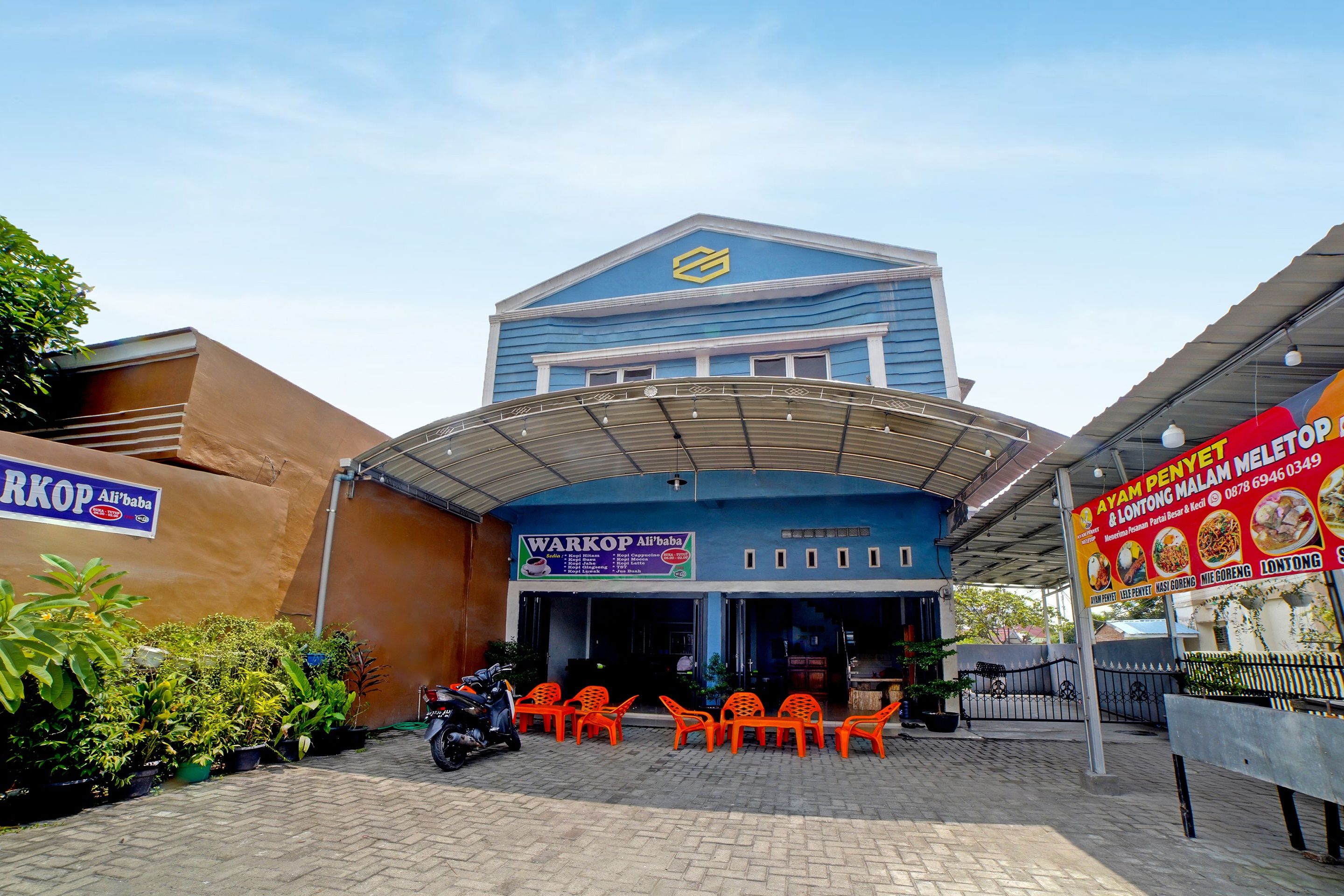 A building with a blue facade and a sign for 'WARKOP Ali'baba' restaurant.
