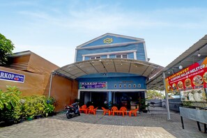 A building with a blue facade and a sign for 'WARKOP Ali'baba' restaurant. - OYO 90922 Gurusinga Guesthouse (Medan)