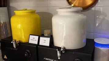 Eine Küchenzeile mit zwei Fissodys-Milchspendern, einer für Sojamilch und einer für Kuhmilch, sowie einem großen weißen Behälter.