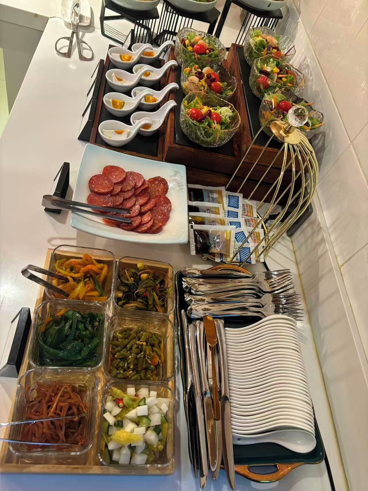 Una mesa de buffet con diferentes alimentos y utensilios.