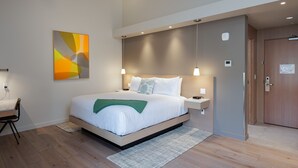 A modern bedroom with a large bed, bedside tables, a desk, and a painting on the wall. - Matia - Luxurious Night’s Sleep (Eastsound)