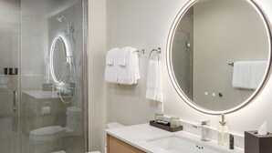 A modern bathroom with a glass-enclosed shower, a toilet, a vanity with a mirror, and a sink. - Matia - Luxurious Night’s Sleep (Eastsound)