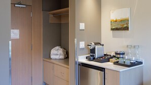 Una cocina moderna con lavavajillas integrado, cafetera y un pequeño rincón de descanso.