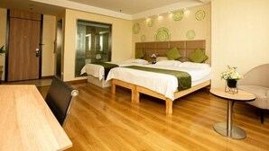 Une chambre d’hôtel avec deux lits, un plancher en bois, un bureau, une chaise et une petite table ronde.