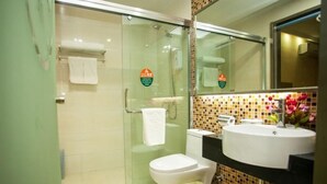 A modern bathroom with a glass shower enclosure, a toilet, a sink with a mirror, and a tiled backsplash. - Greentree Inn Jiangsu Xuzhou Feng County Liubang Plaza Express Hotel (Xuzhou)