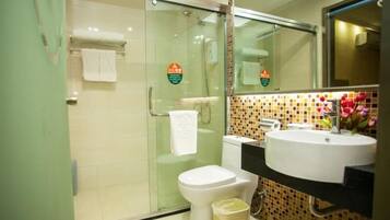 A modern bathroom with a glass shower enclosure, a toilet, a sink with a mirror, and a tiled backsplash.