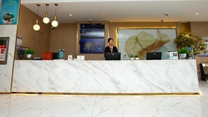 A hotel reception area with a marble counter, a receptionist, and a large leaf artwork on the wall. - Greentree Inn Jiangsu Xuzhou Feng County Liubang Plaza Express Hotel (Xuzhou)