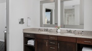 A modern bathroom with two sinks, dark wood cabinets, and a large mirror.