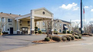 A hotel with a covered entrance, a signboard, and a flag. - Quality Inn Ruston (Ruston)