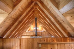 Cozy cabin with a central chimney and high ceiling, perfect for a warm retreat.