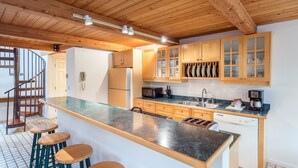 A modern kitchen with wooden cabinets, a stainless steel sink, and a built-in dishwasher. - Mountainside Inn 101 2 Bedroom Condo by Alpine Lodging Telluride (Telluride)