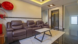 Una sala de estar moderna con un sofá modular, piso de mármol e iluminación empotrada en el techo.