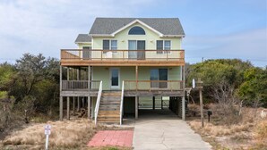 A two-story house with a balcony, a staircase, and a no parking sign. - SomerVilla: Oceanside | Pool/Hot Tub | Pets OK (Corolla)