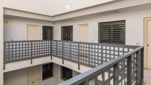 A multi-level building with a central open space, multiple doors, and windows with blinds. - Welcome Apartment, in the center of Malaga! (Málaga)