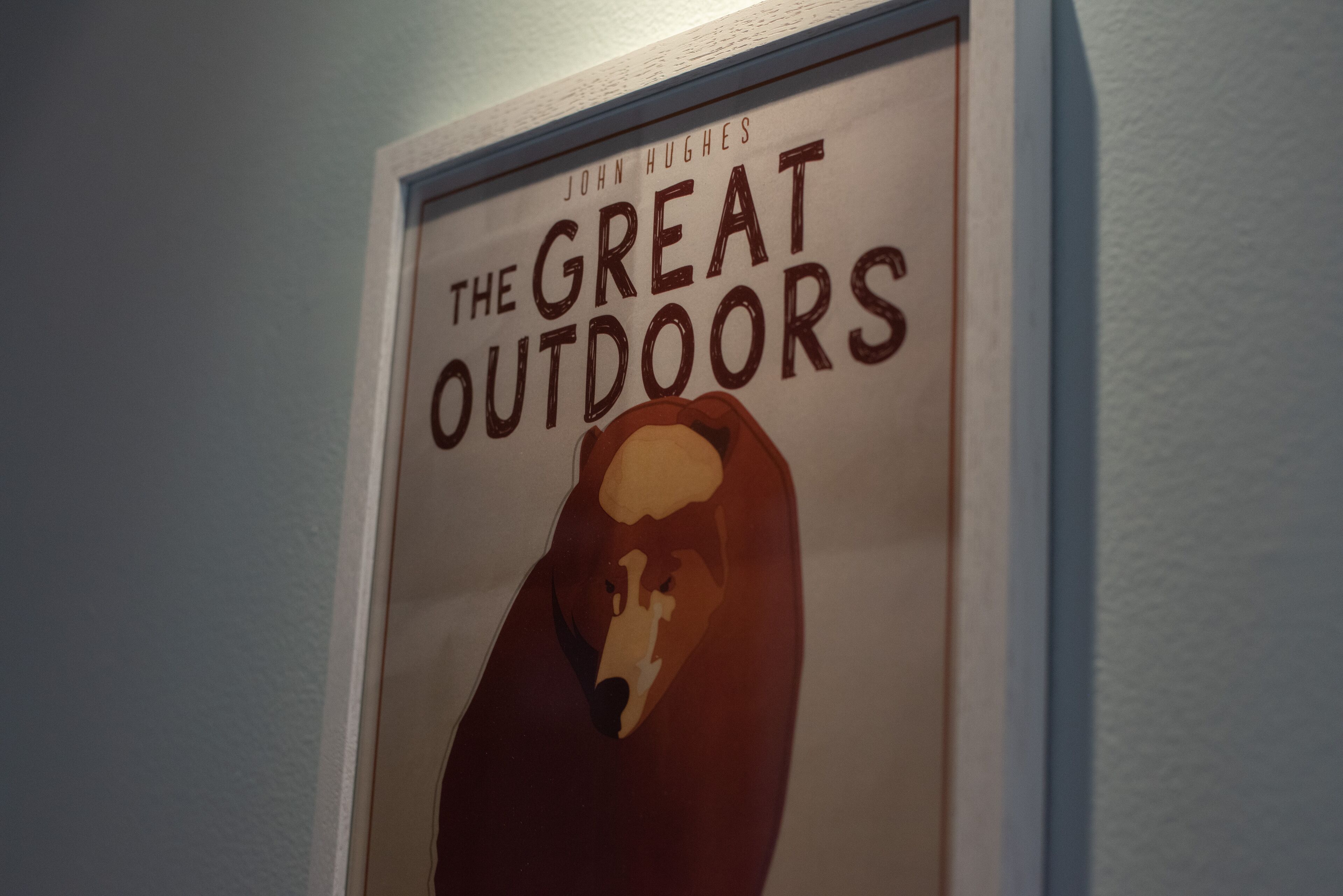 A framed poster with the title "The Great Outdoors" and the author's name "John Hughes".
