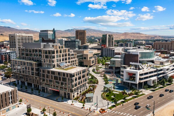 Un quartier urbain moderne comprenant divers bâtiments, notamment un grand immeuble de bureaux et un complexe commercial.