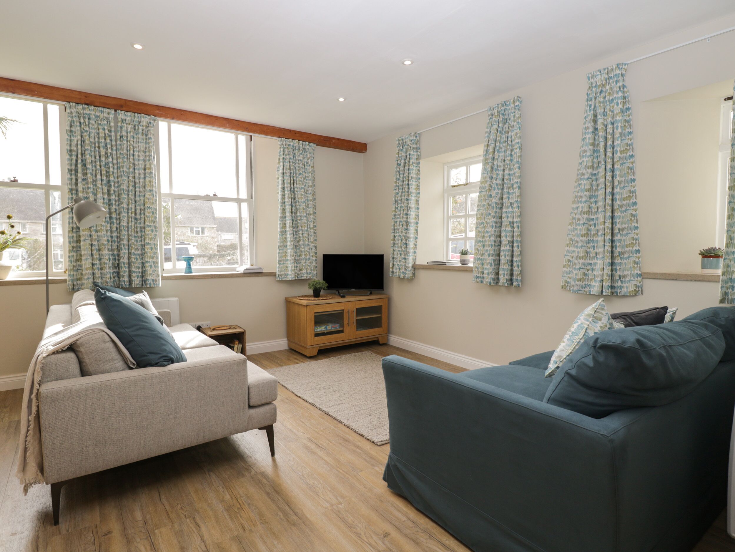 A living room with a sofa, a television, and a cabinet.