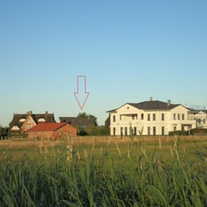 A residential area with houses and a field in the foreground.