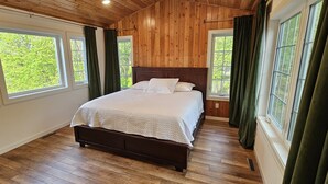 A bedroom with a wooden ceiling, a large bed, and multiple windows with curtains. - Beautiful lake house with pontoon INCLUDED! (Vergas)