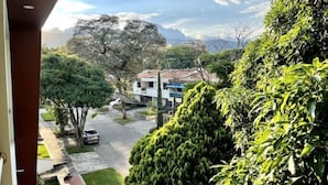 Un quartier résidentiel avec un bâtiment blanc, des arbres verdoyants et un ciel dégagé.