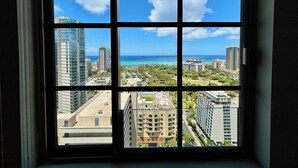 Una ventana con vista a un paisaje urbano, incluyendo edificios altos y una playa.