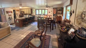A spacious living area with a kitchen, dining table, and a cozy seating area.