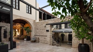 A hotel lobby with a stone archway, a seating area, and a staircase leading to the upper floor. - Wyndham Tarsus St.Paul (Tarsus)