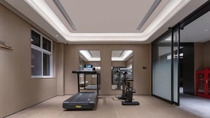Een moderne sportschool met loopbanden, spinningfietsen en een spiegelwand.