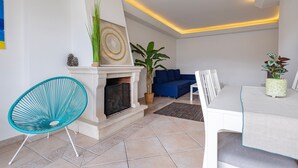 Una sala moderna con chimenea, una mesa de comedor y sillas azules.