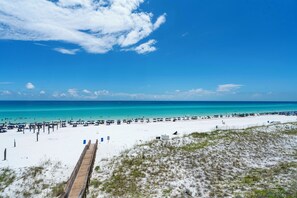 A beach with a wooden boardwalk leading to the shore, a sandy beach, and a clear blue sky. - Crystal Sands 309a - Gulf Front, Free Beach Service, Heated Pool, Sleeps 9 (Destin)