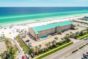 A hotel with a swimming pool, beach access, and a parking lot. - Crystal Sands 309a - Gulf Front, Free Beach Service, Heated Pool, Sleeps 9 (Destin)