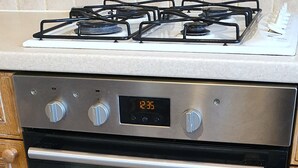 Une cuisine équipée d’un four encastré et d’une cuisinière à gaz.