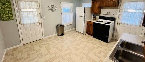 A compact kitchen with a refrigerator, stove, and sink.