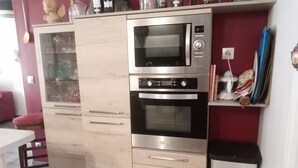 A kitchen with a built-in microwave and oven, wooden cabinets, and a red wall. - House between sea and mountains located in a quiet cul-de-sac Animals accepted  (Pollestres)