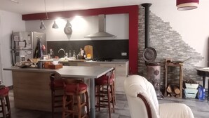 A modern kitchen with a central island, bar stools, and a dining area with a white chair. - House between sea and mountains located in a quiet cul-de-sac Animals accepted  (Pollestres)