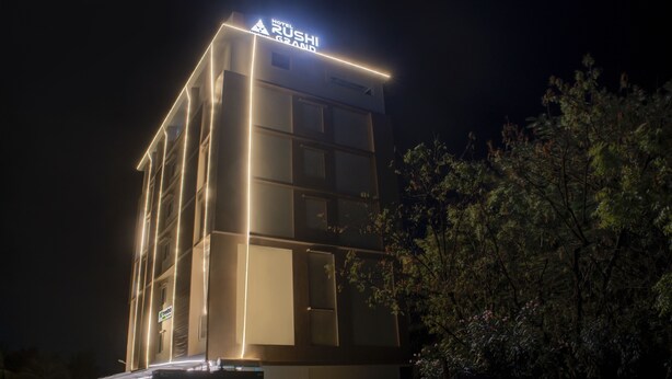 Un moderno edificio de hotel por la noche con señalización iluminada.
