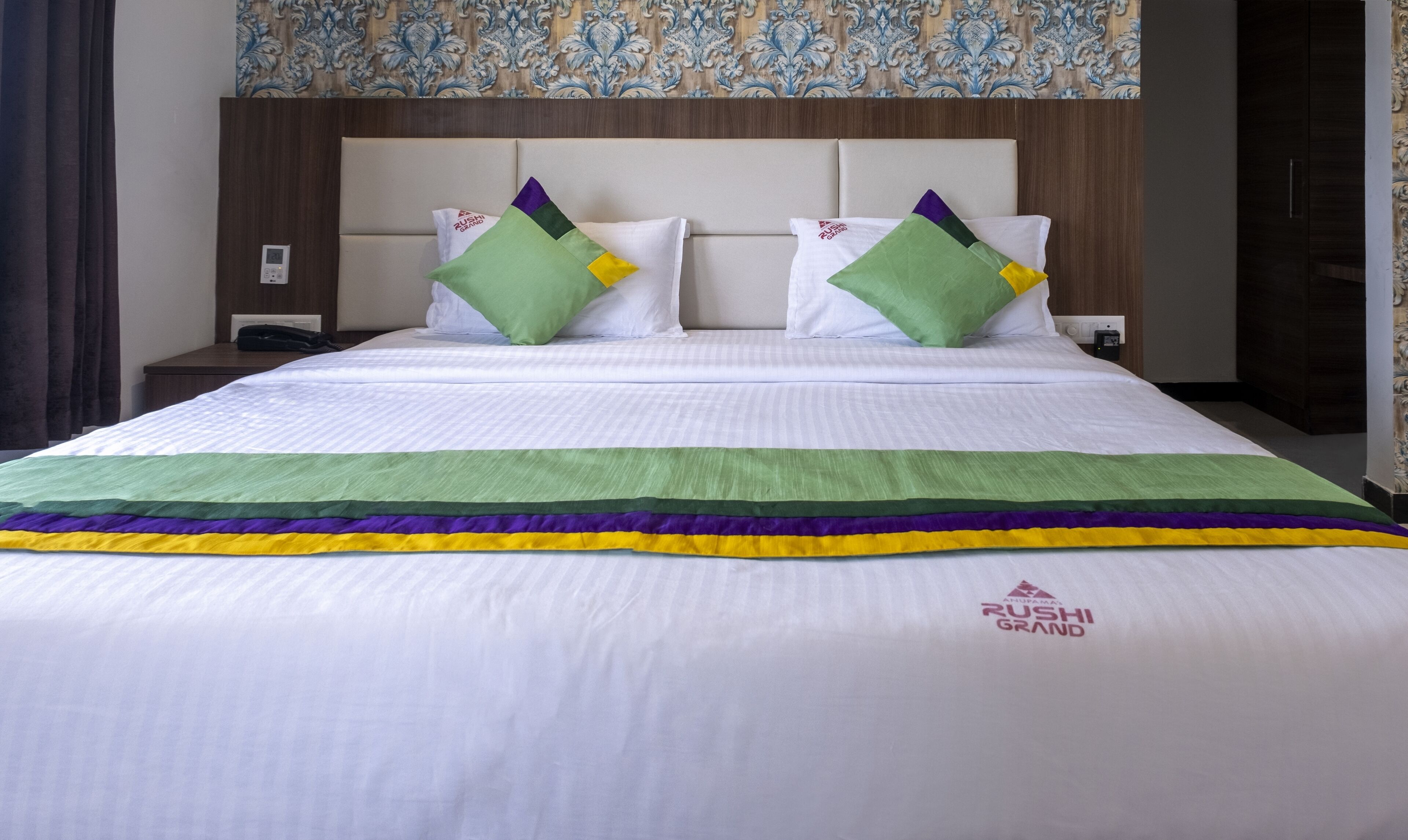 Ein Hotelzimmer mit einem Bett, zwei Kissen, einem Nachttisch und einem Beistelltisch.