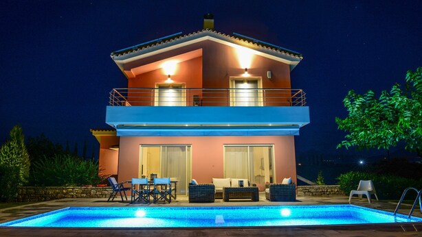 Una casa a due piani con una piscina di fronte.