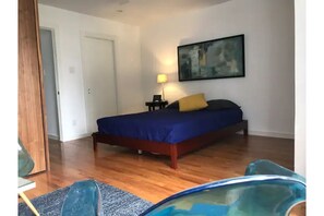 Relax in a spacious room with a large bed, nightstand, and framed picture.