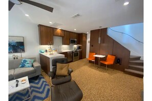 Cozy living space with a central kitchen, sofa, and coffee table.